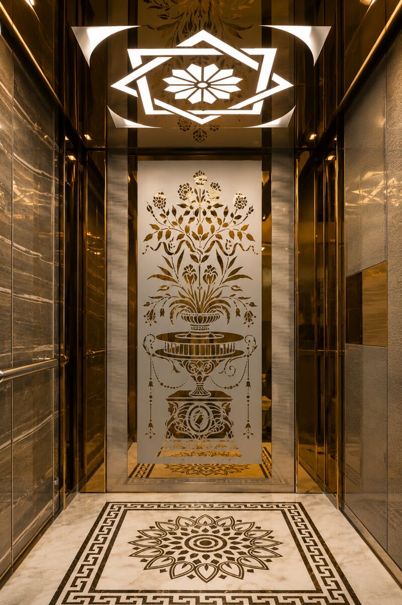 Ornate golden elevator cabin interior with etched panels